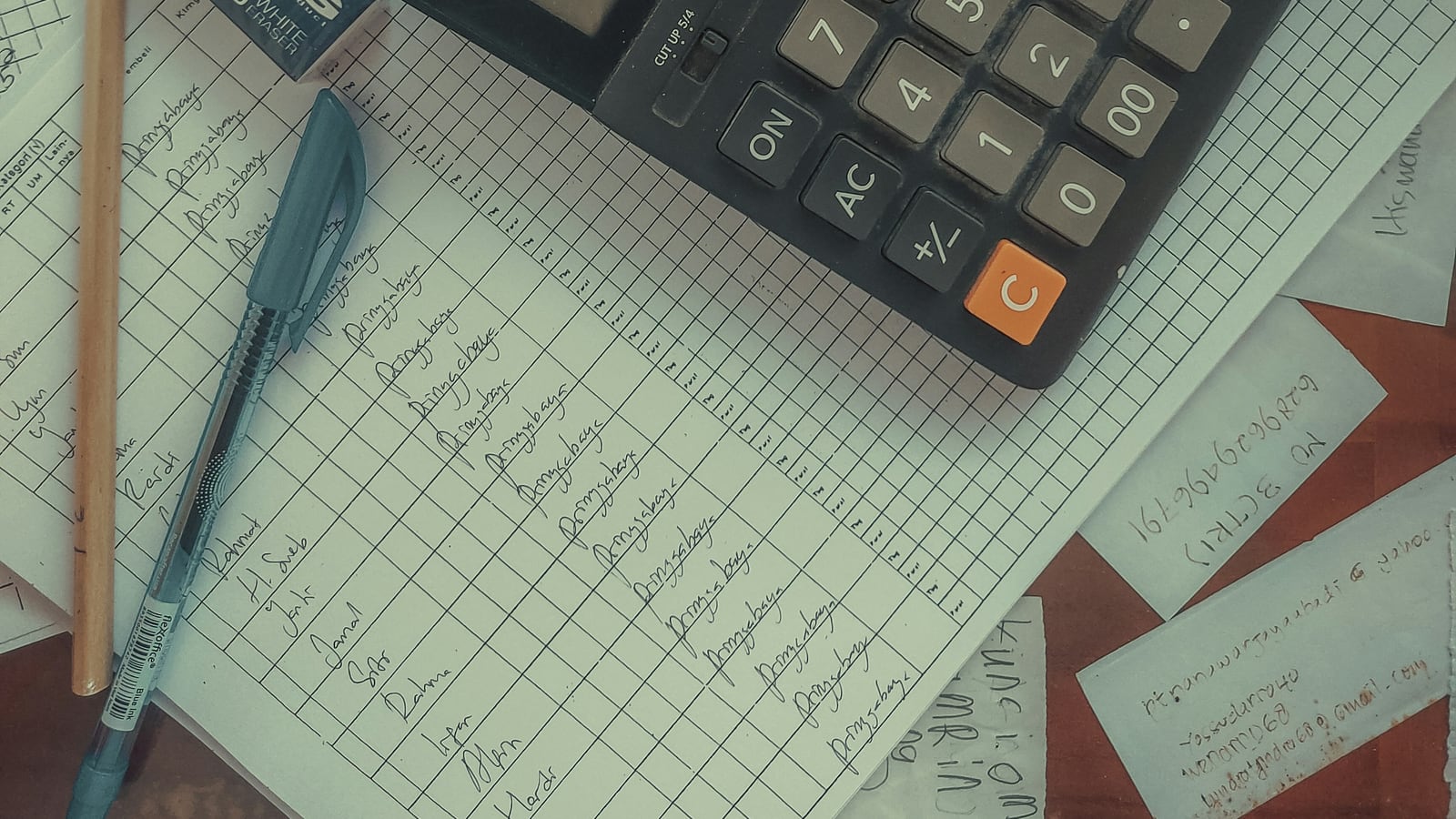 Calculator and accounting documents arranged on a desk for a cost review
